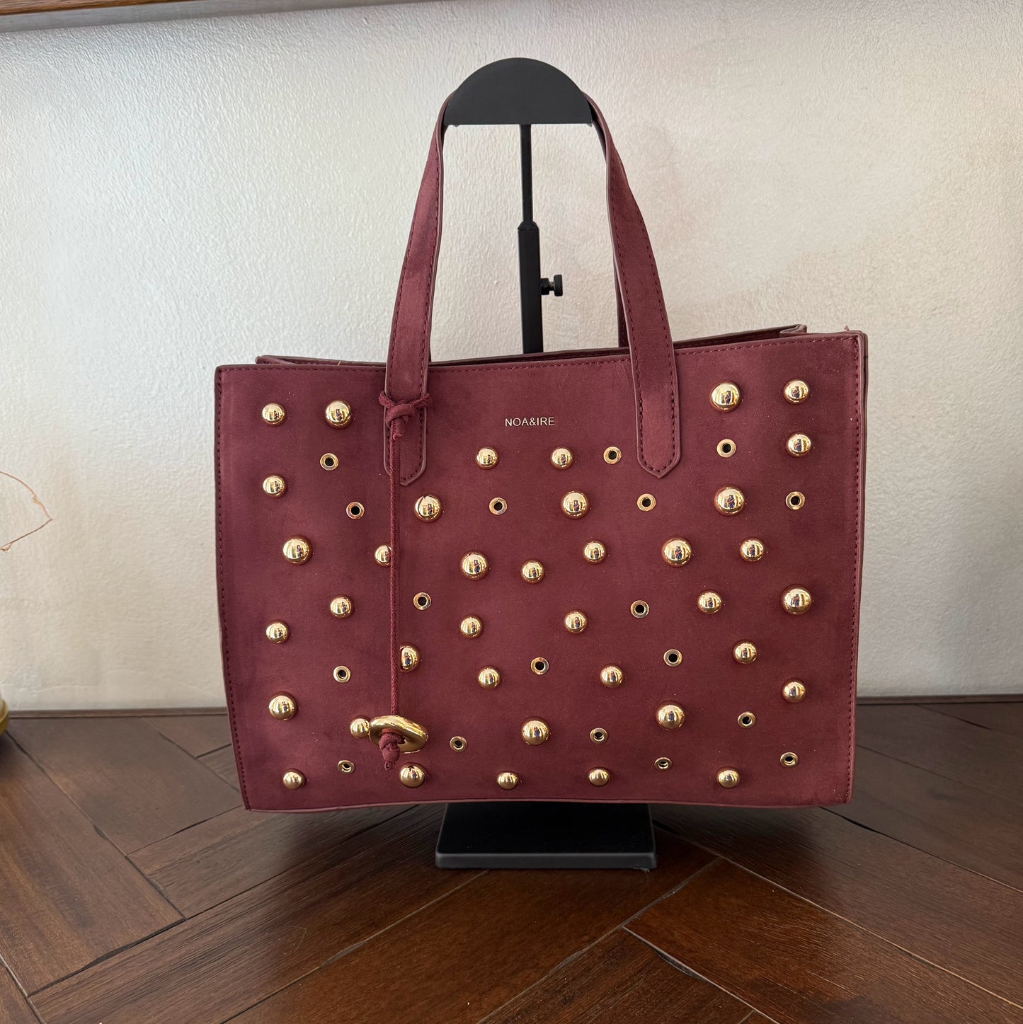 Bolso shopper con tachuelas metálicas con asa de mano y larga para colgar.