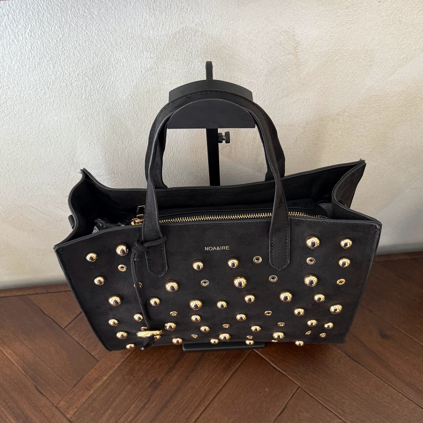Bolso shopper con tachuelas metálicas con asa de mano y larga para colgar.