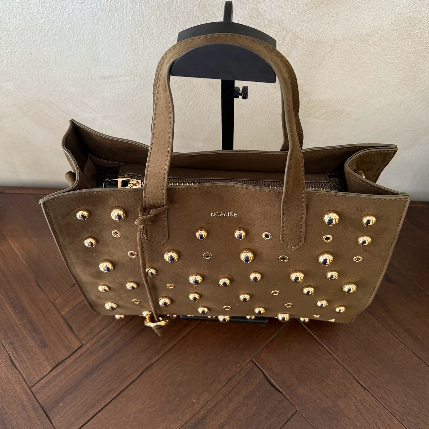Bolso shopper con tachuelas metálicas con asa de mano y larga para colgar.