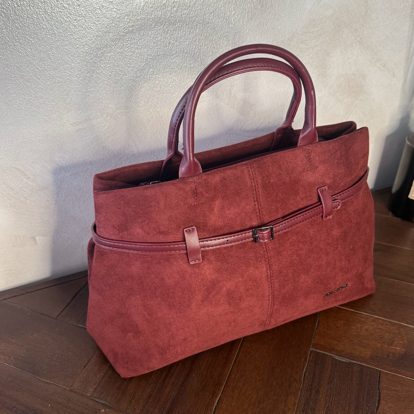 Bolso de mano de antelina elegante y sofisticado con asa larga.