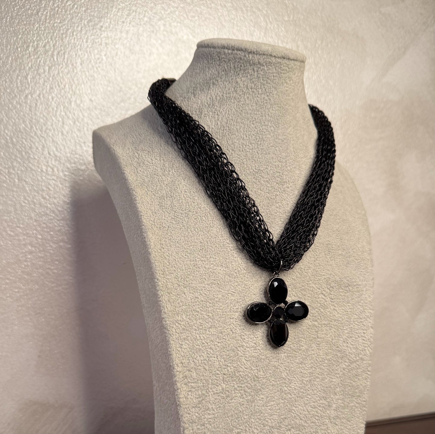 Collar con colgante de cruz y piedras facetadas.