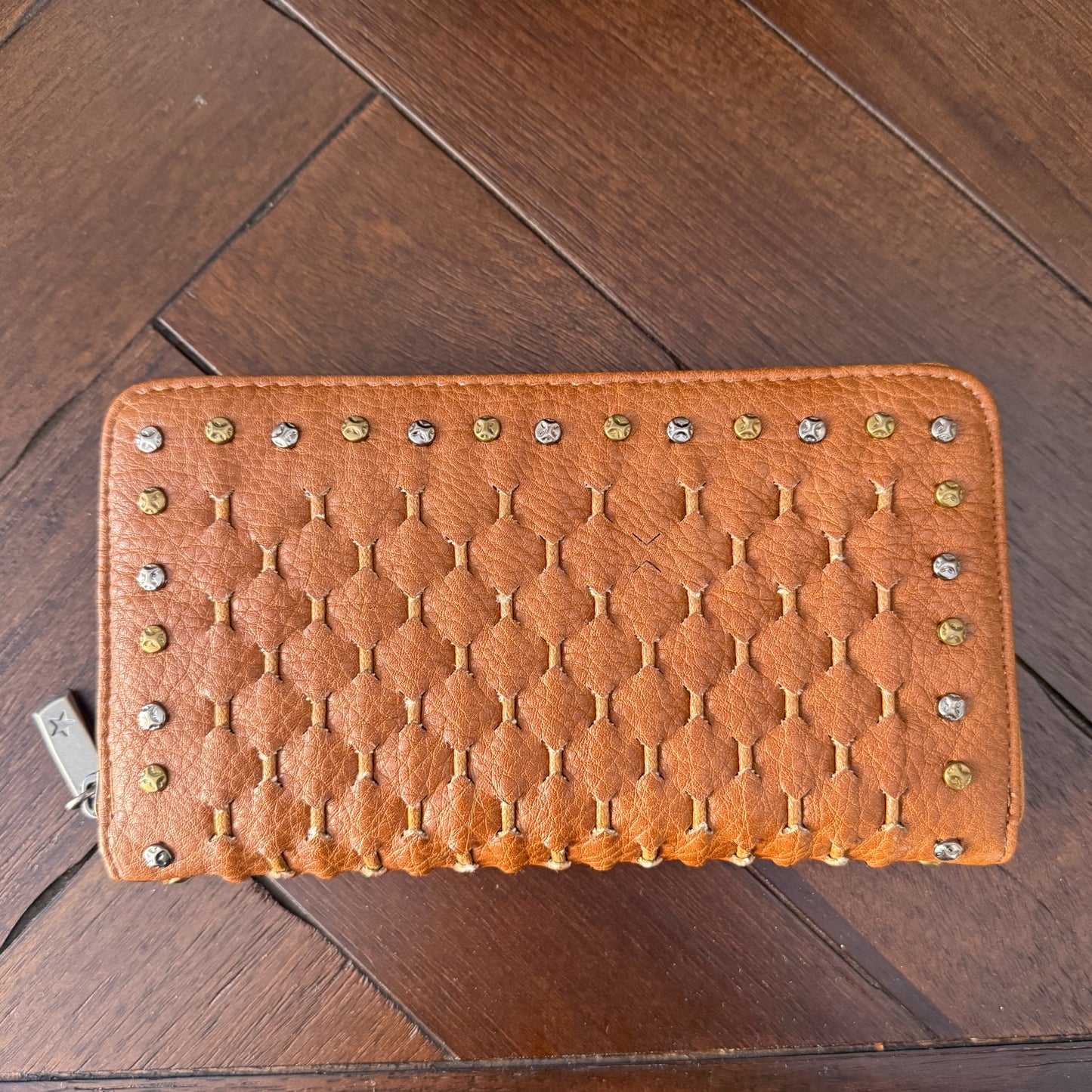 Monedero cerrado con cremallera trenzado con tachuelas.