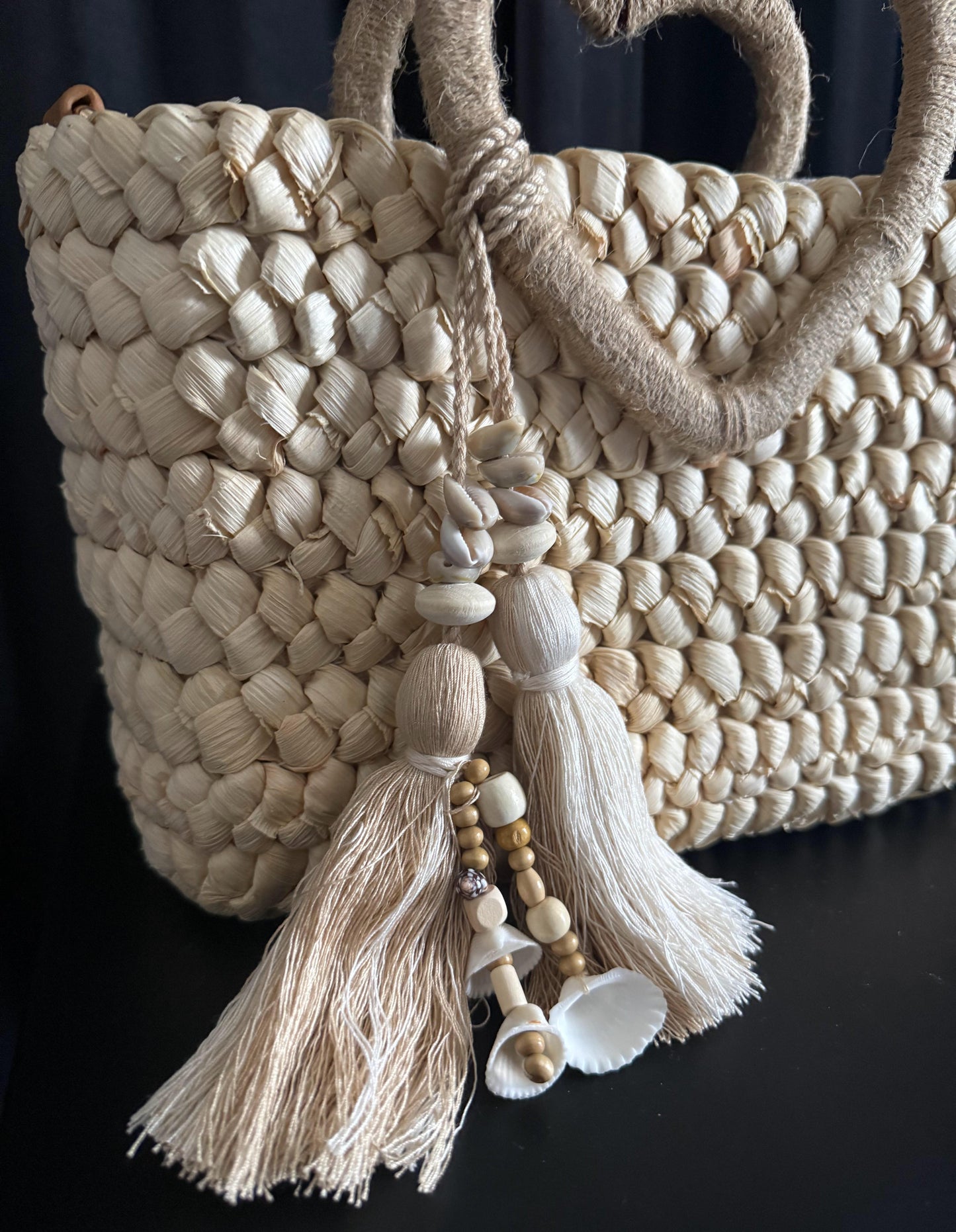 Capazo trenzado con asa en forma de corazón y detalles boho, perfecto para un estilo romántico y veraniego