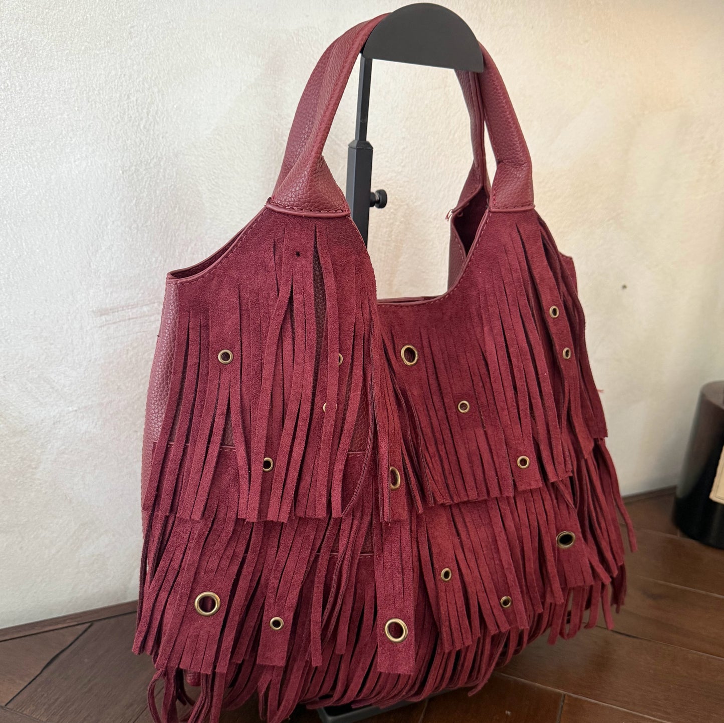 Bolso de mano con asa larga de flecos y aros metálicos
