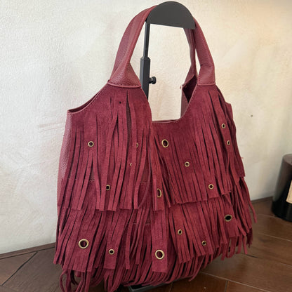 Bolso de mano con asa larga de flecos y aros metálicos
