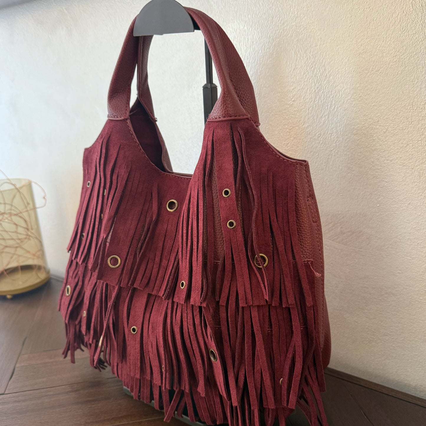 Bolso de mano con asa larga de flecos y aros metálicos
