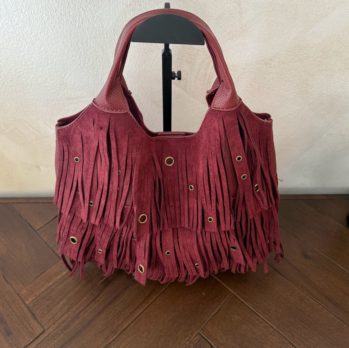 Bolso de mano con asa larga de flecos y aros metálicos