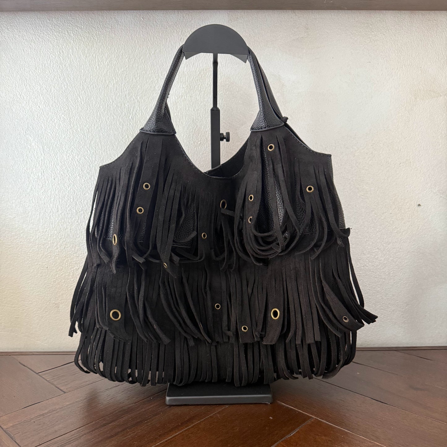 Bolso de mano con asa larga de flecos y aros metálicos