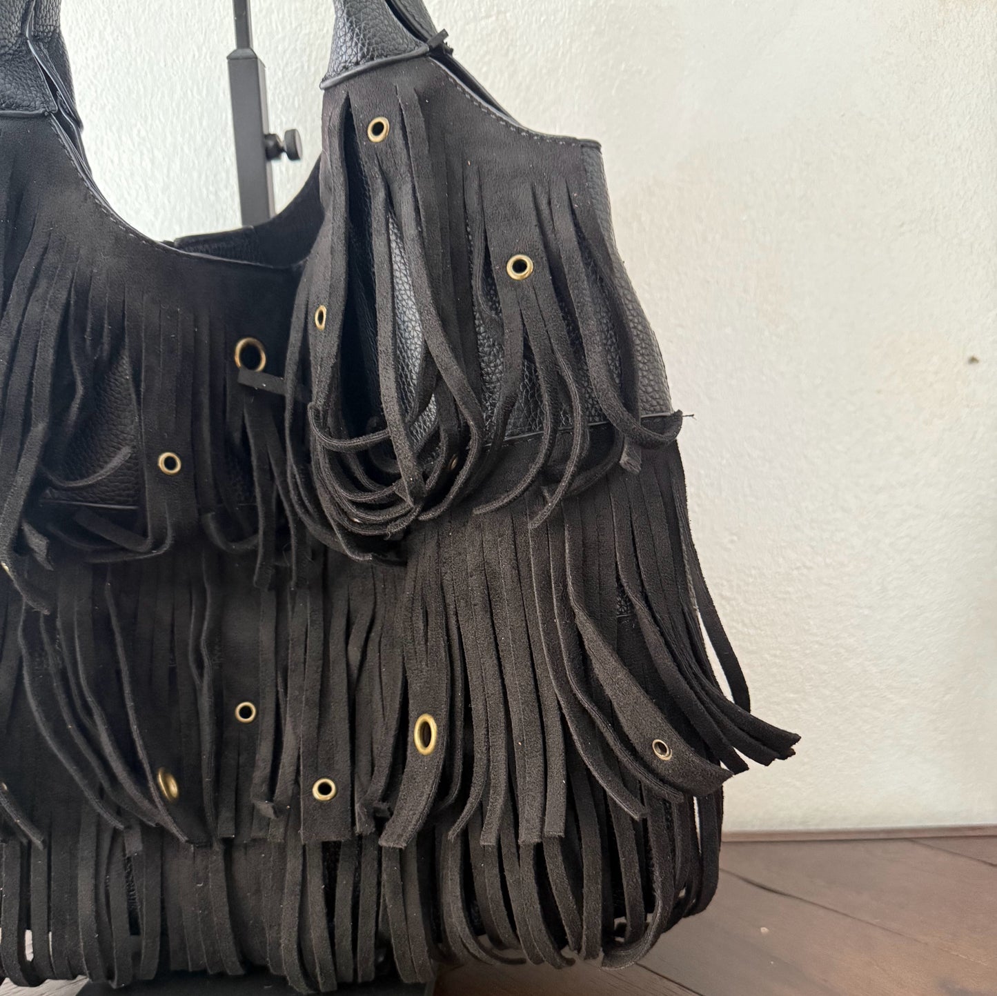 Bolso de mano con asa larga de flecos y aros metálicos