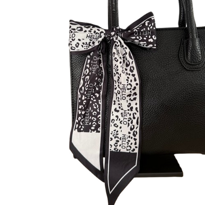 Bolso negro elegante con pañuelo decorativo y asa larga extraíble