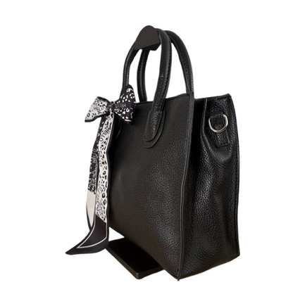 Bolso negro elegante con pañuelo decorativo y asa larga extraíble