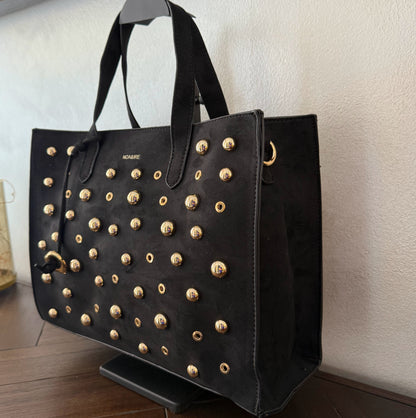 Bolso shopper con tachuelas metálicas con asa de mano y larga para colgar.