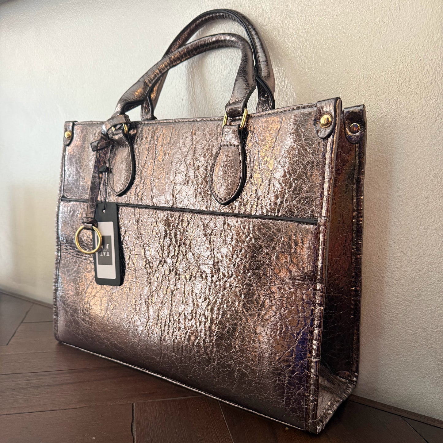 Cartera metalizada con con asa de mano y asa larga.