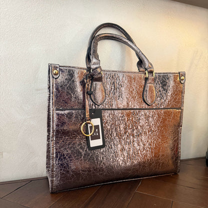 Cartera metalizada con con asa de mano y asa larga.