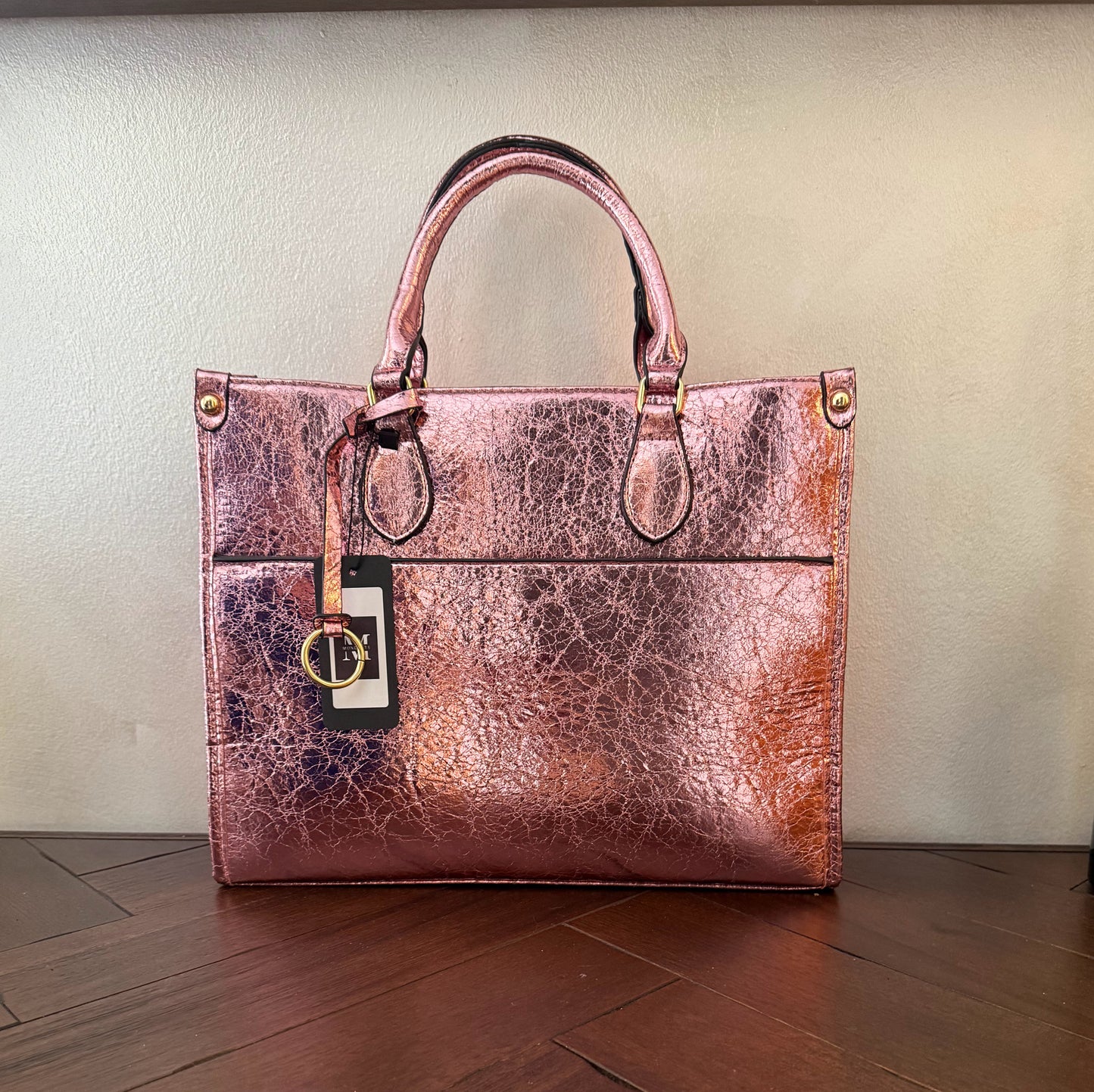 Cartera metalizada con con asa de mano y asa larga.
