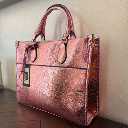 Cartera metalizada con con asa de mano y asa larga.