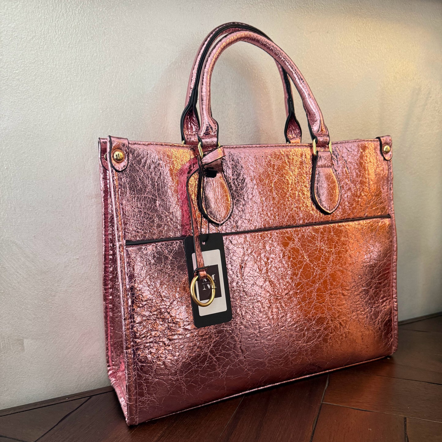 Cartera metalizada con con asa de mano y asa larga.