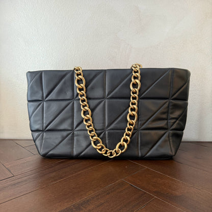 Bolso acolchado con asas de cadena dorada.