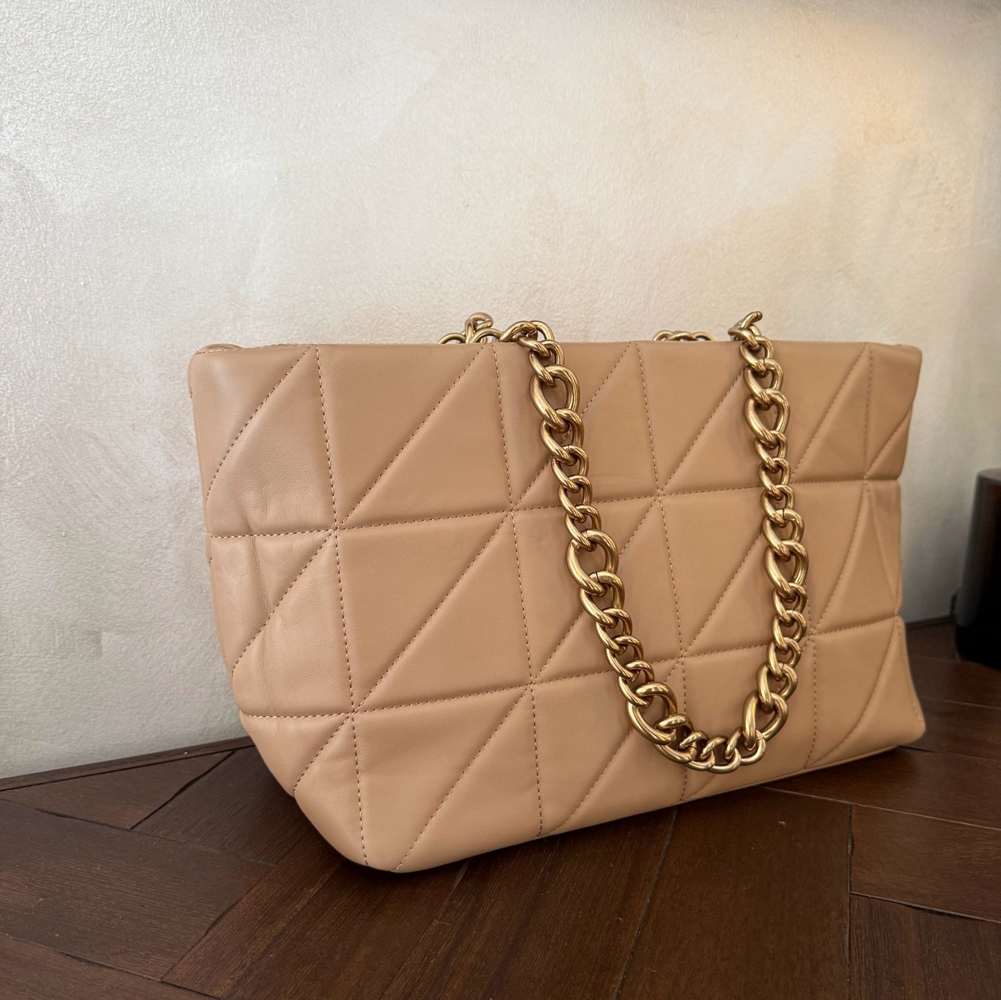 Bolso acolchado con asas de cadena dorada.