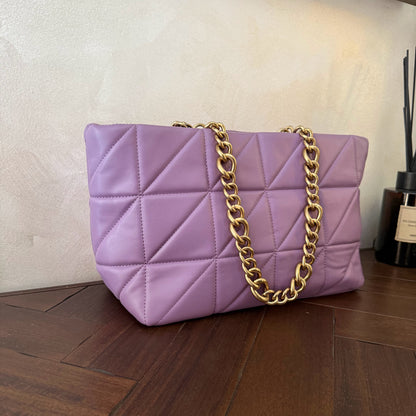 Bolso acolchado con asas de cadena dorada.