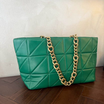 Bolso acolchado con asas de cadena dorada.
