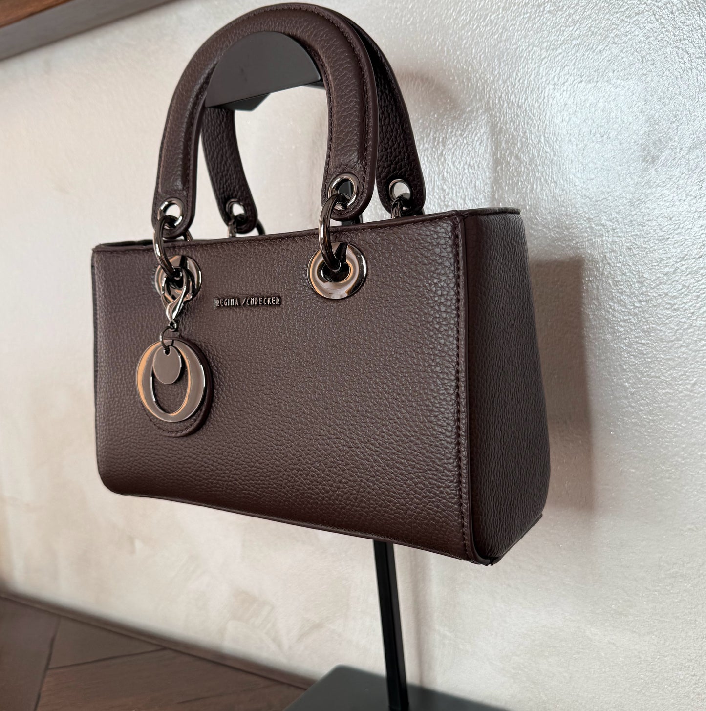 Bolso de mano con asa larga y colgante metálico