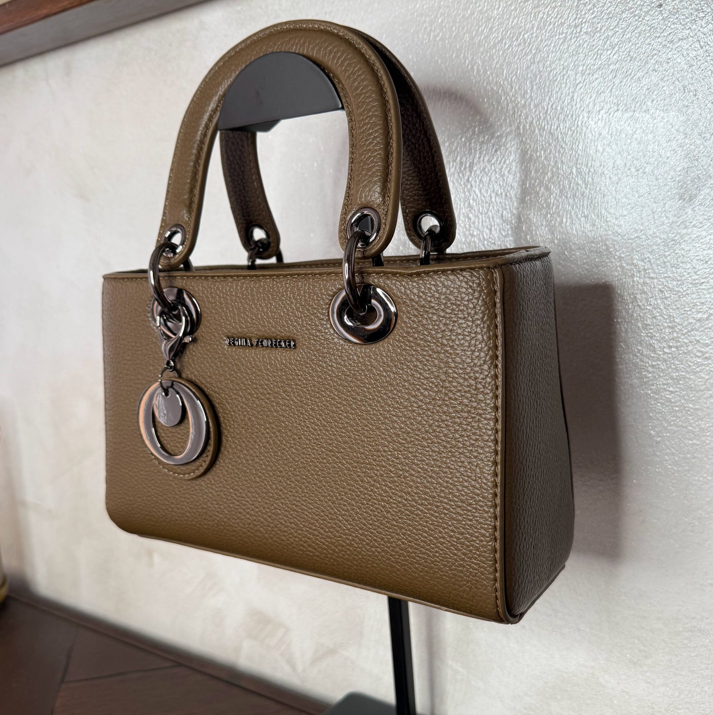 Bolso de mano con asa larga y colgante metálico
