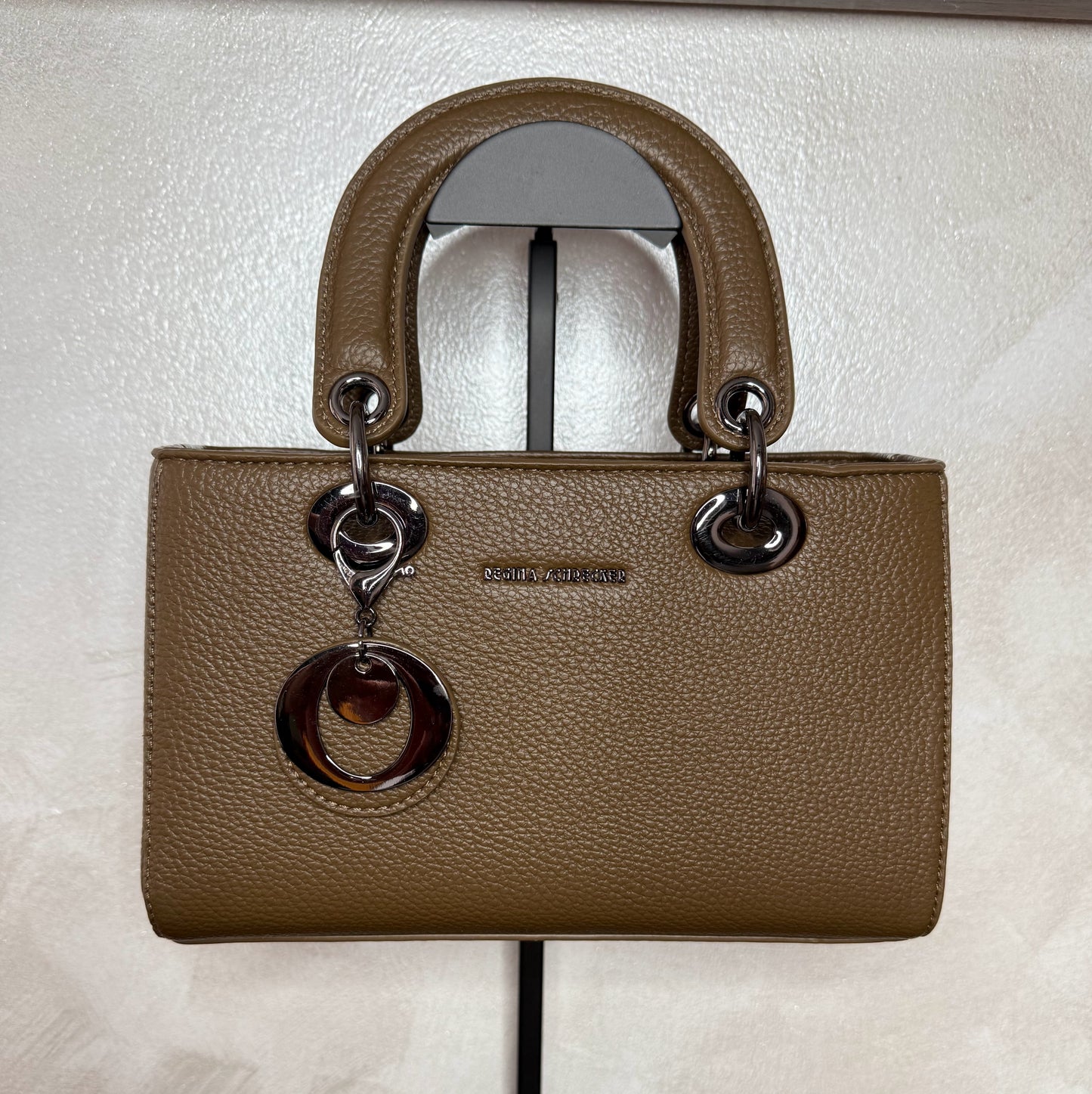 Bolso de mano con asa larga y colgante metálico