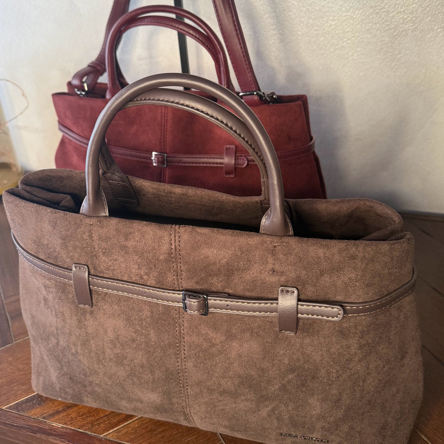 Bolso de mano de antelina elegante y sofisticado con asa larga.