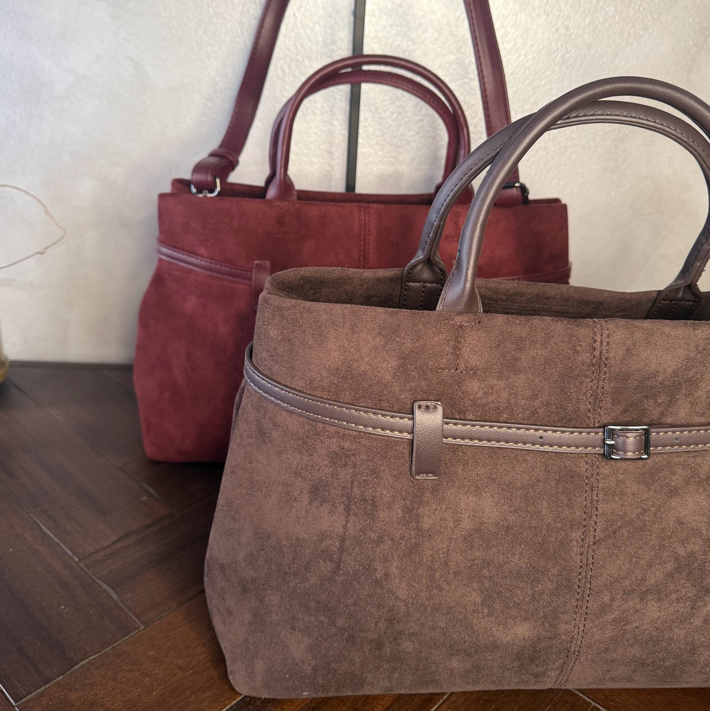 Bolso de mano de antelina elegante y sofisticado con asa larga.