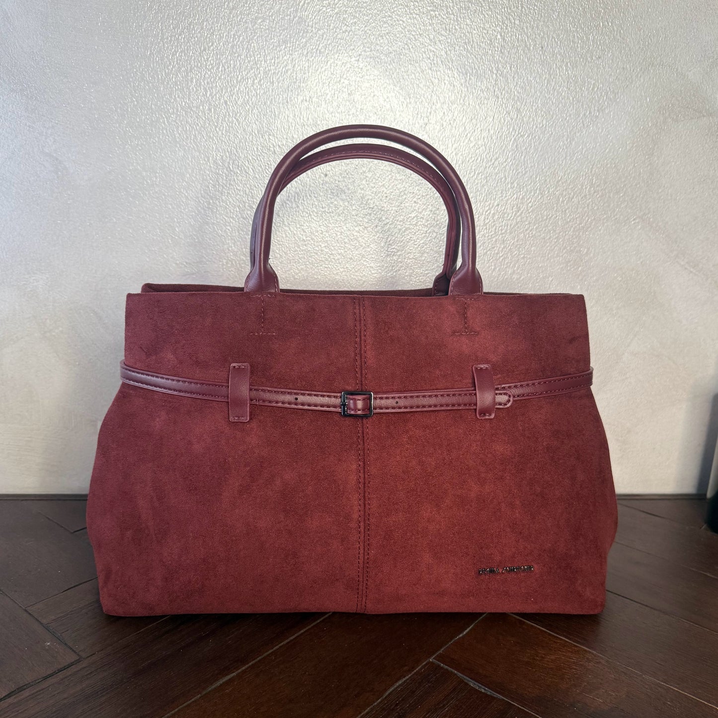 Bolso de mano de antelina elegante y sofisticado con asa larga.