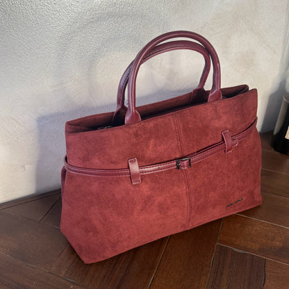 Bolso de mano de antelina elegante y sofisticado con asa larga.