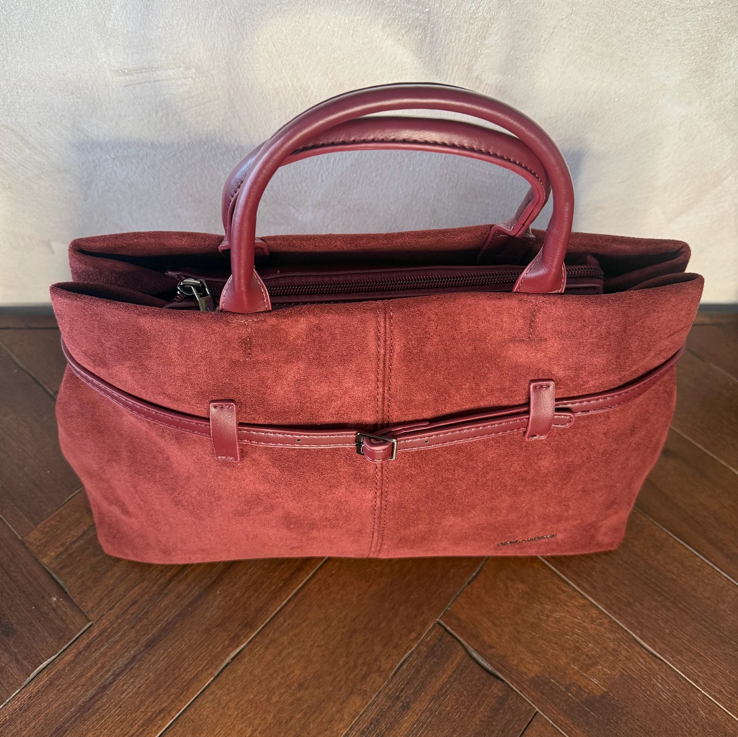 Bolso de mano de antelina elegante y sofisticado con asa larga.