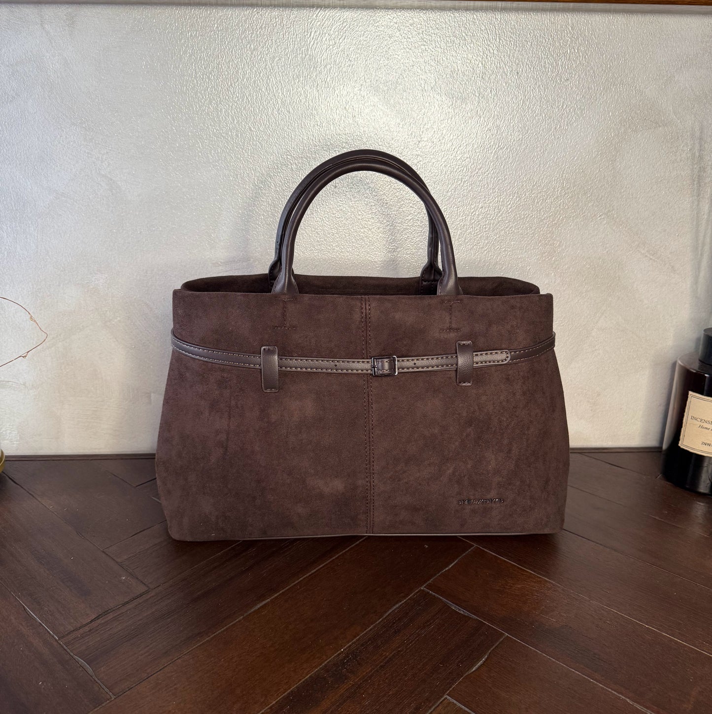 Bolso de mano de antelina elegante y sofisticado con asa larga.