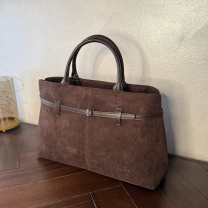 Bolso de mano de antelina elegante y sofisticado con asa larga.