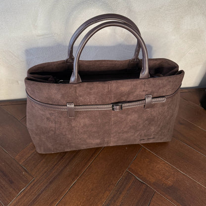 Bolso de mano de antelina elegante y sofisticado con asa larga.