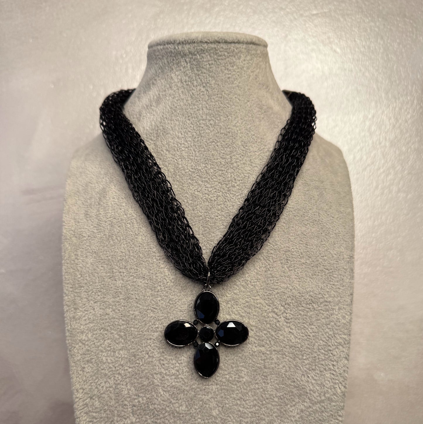 Collar con colgante de cruz y piedras facetadas.