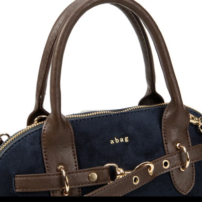 Detalle del logotipo físico del bolso satchel