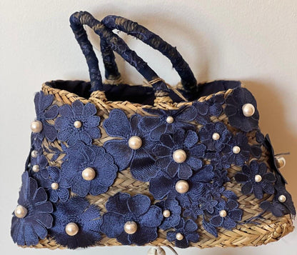 Capazo de rafia con flores bordadas en azul marino y perlas: un toque artesanal y elegante. Pequeño