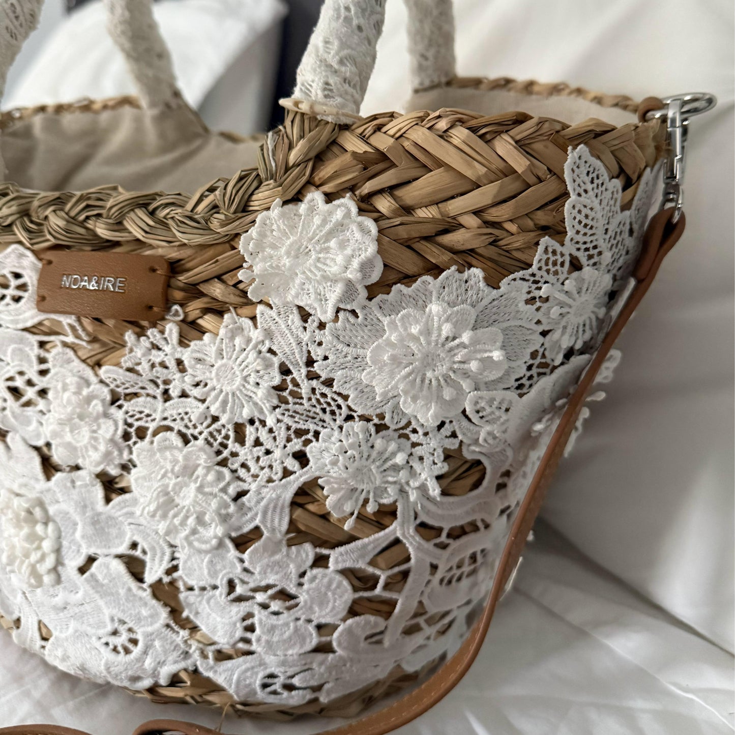 Capazo de rafia natural con encaje floral, ideal para un look bohemio y elegante